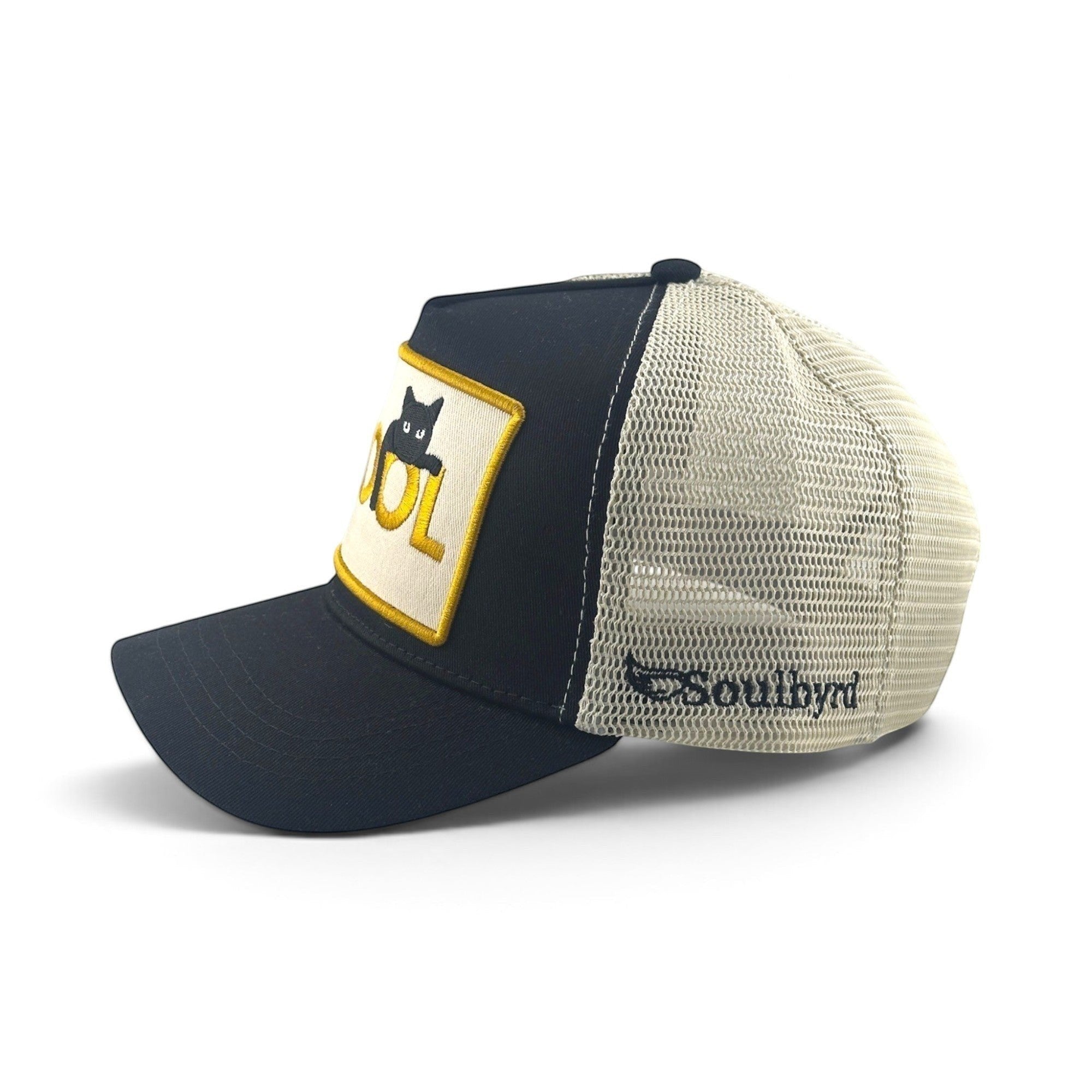 Soulbyrd Wholesale black cotton trucker hat with mesh back, featuring a Cool Cat patch and side logo embroidery.