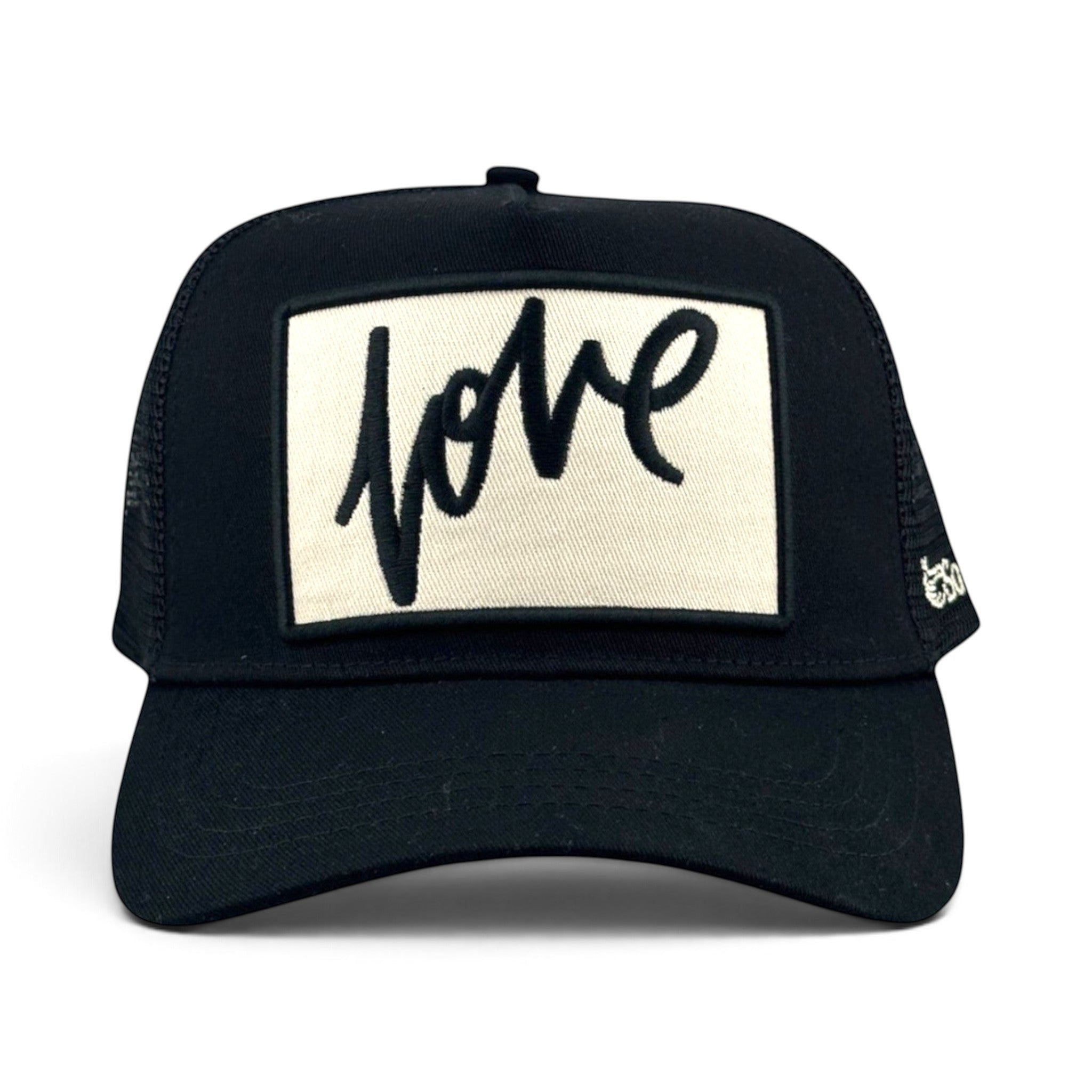 Soulbyrd Wholesale black trucker hat with a white rectangular patch featuring the word Love in black cursive script.