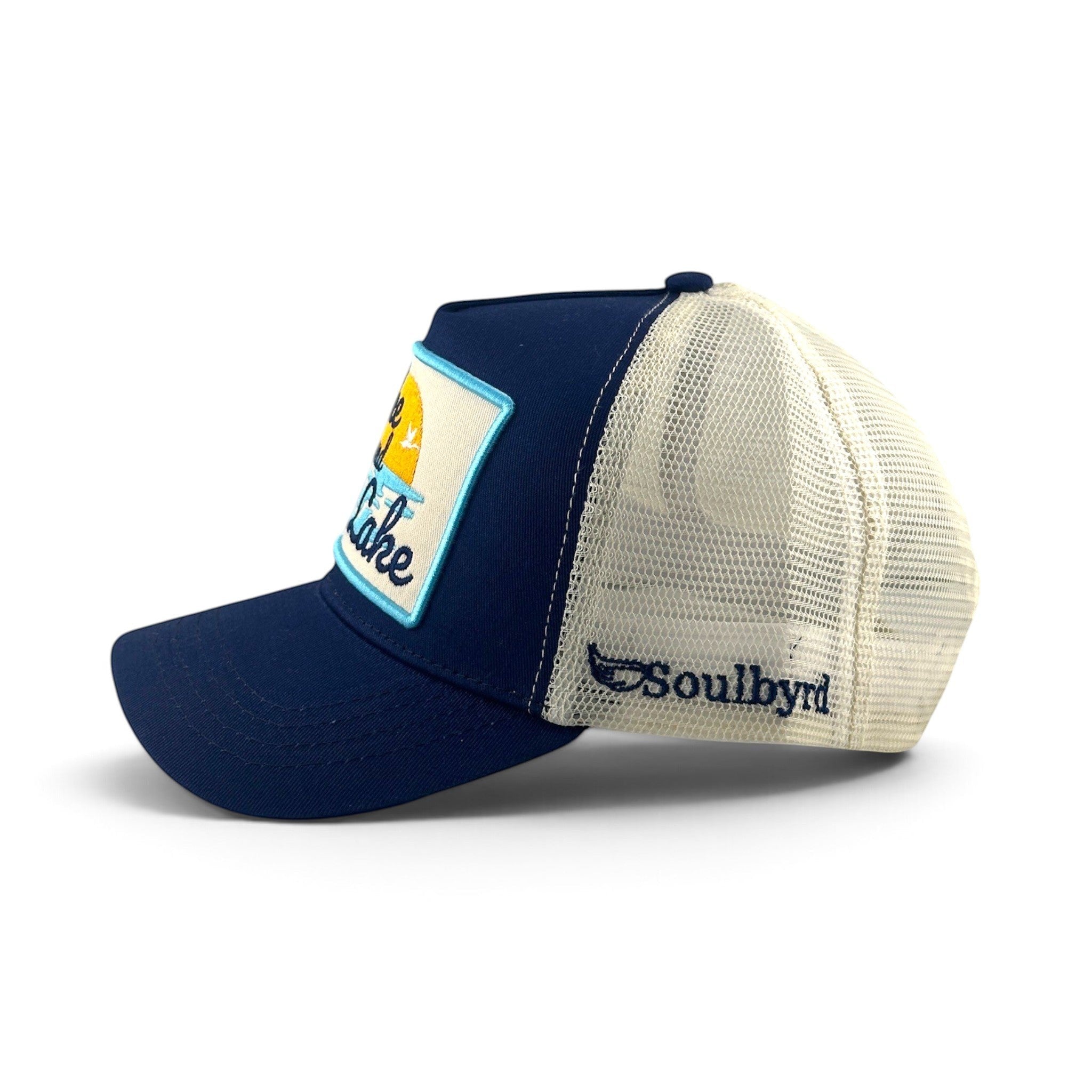 Soulbyrd Wholesale blue 5-panel trucker hat with cotton twill front, nylon mesh back, and Wake & Lake patch.