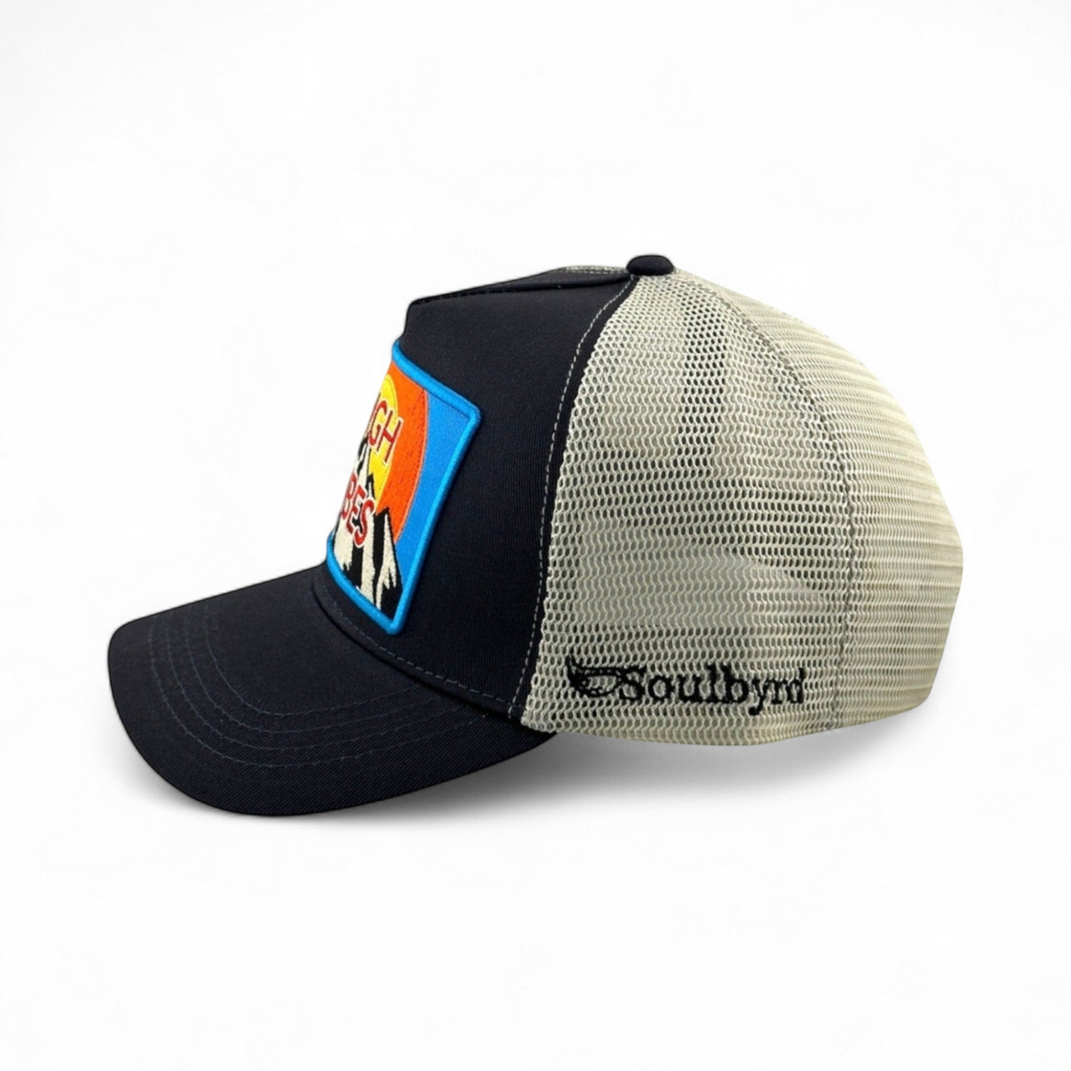 Soulbyrd Wholesale charcoal trucker hat with cotton twill front, nylon mesh back, and High Vibes graphic patch.