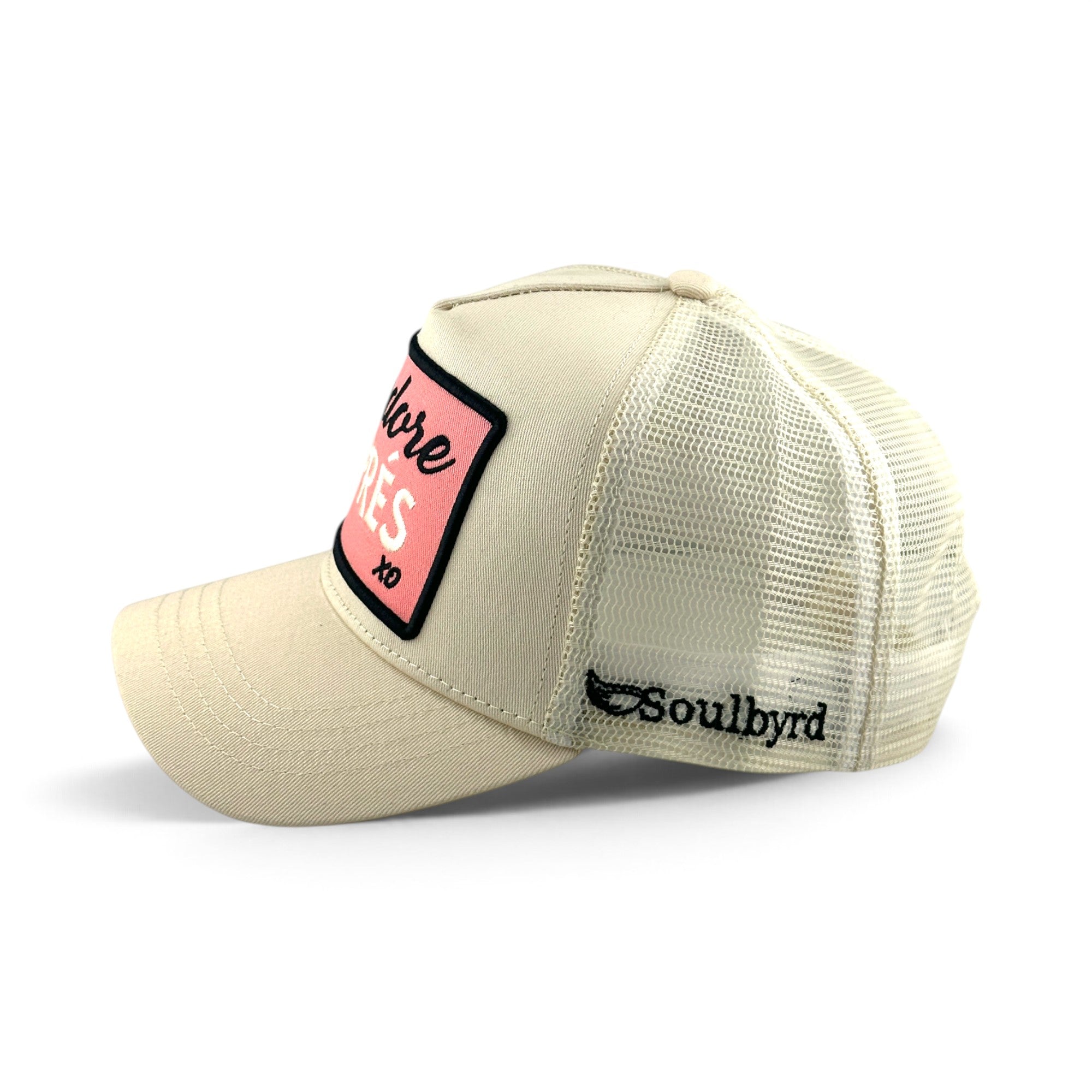Soulbyrd Wholesale ivory trucker hat with pink J'adore Aprés patch, cotton twill front, and breathable nylon mesh back