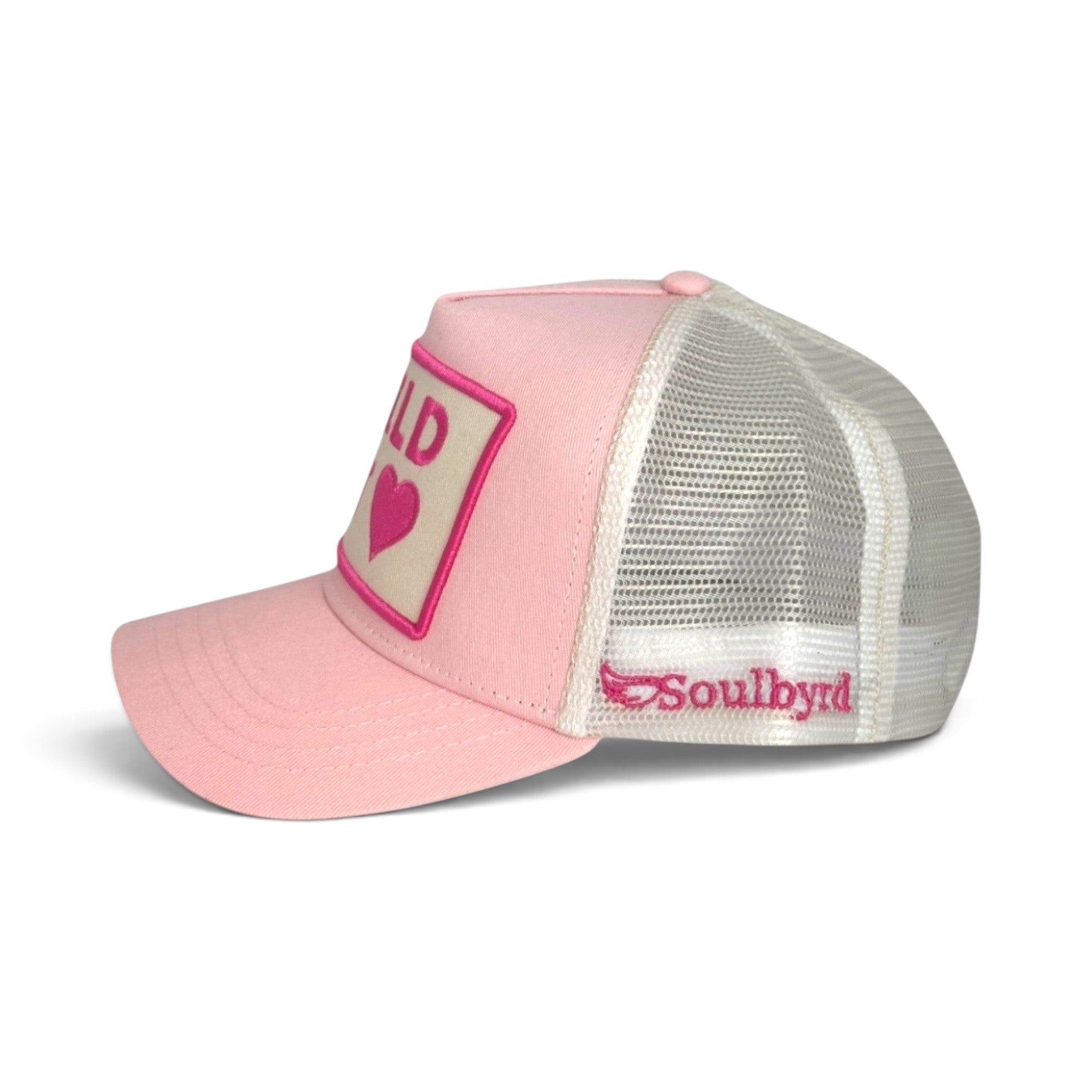 Soulbyrd Wholesale pink trucker hat with Wild at Heart patch, cotton twill crown, and breathable white nylon mesh.