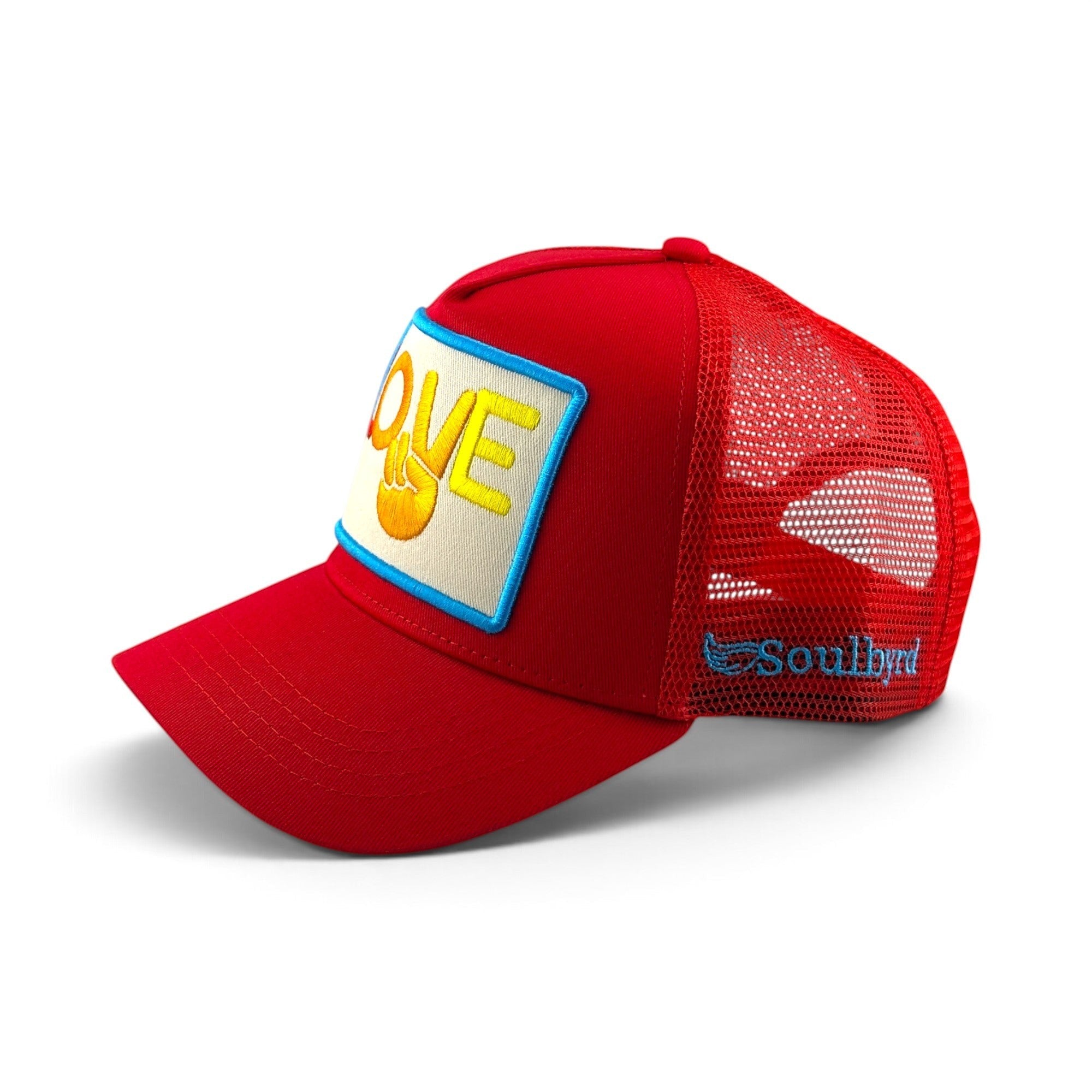 Soulbyrd Wholesale red trucker hat with a Love and peace sign patch, cotton twill crown, and breathable nylon mesh.